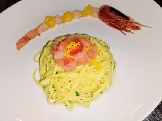 Restaurant Spaghetti mit Garnelen und Tomaten auf weißem Teller angerichtet