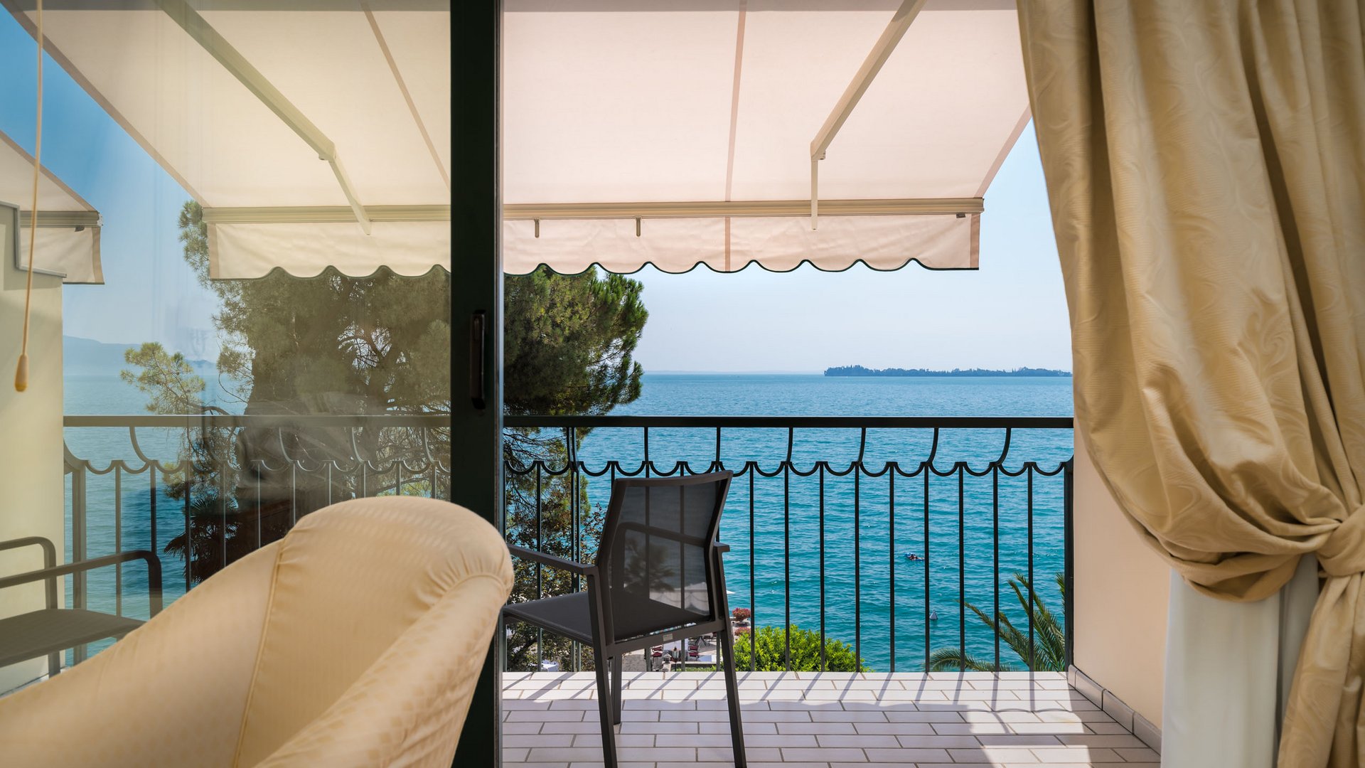 Seeblick wie aus einem Gemälde Balkon mit Stuhl und Blick auf das Meer an einem sonnigen Tag