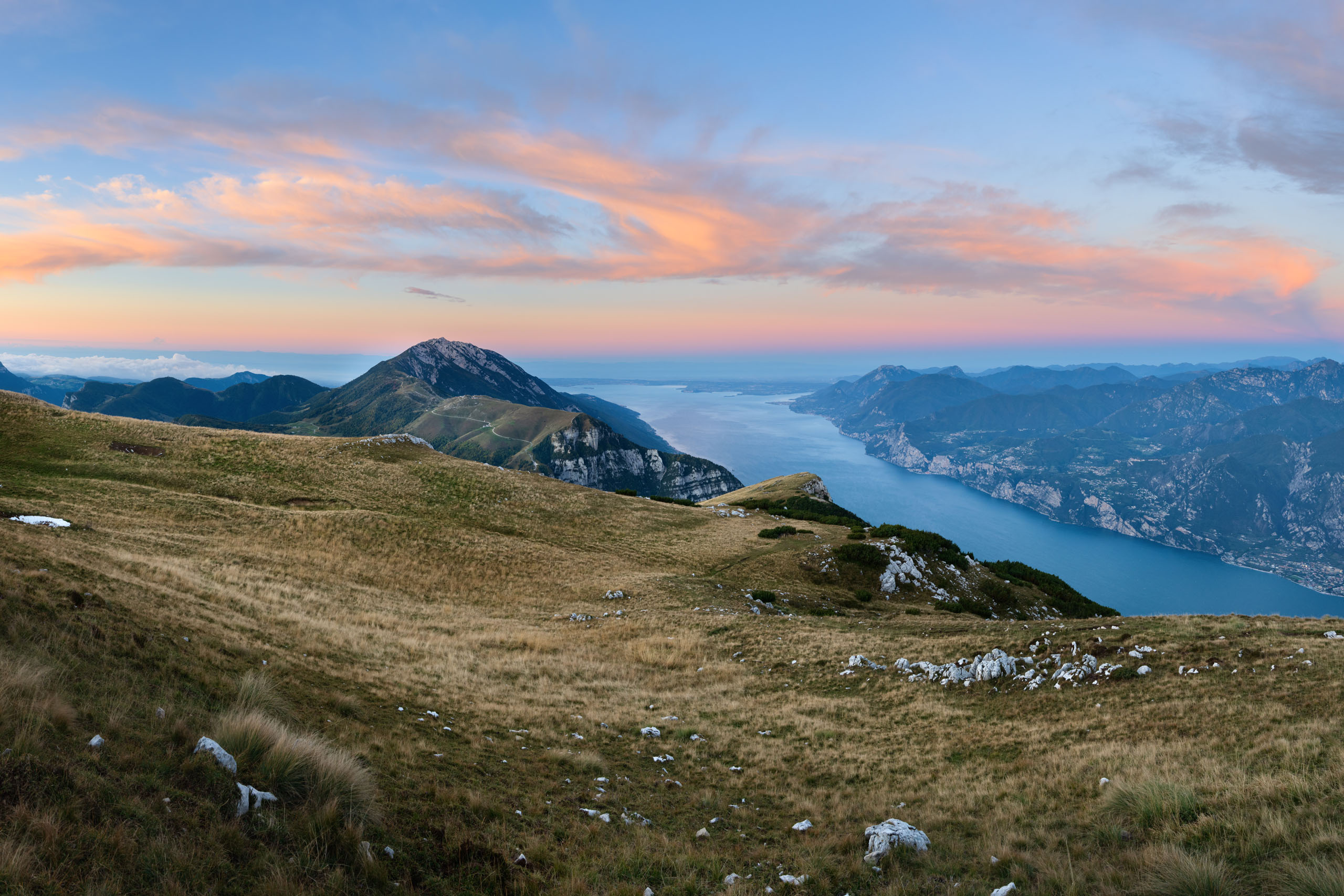 So viele Möglichkeiten für Euren Sommerurlaub am Gardasee! Blick auf einen See und Berge im Sonnenuntergang